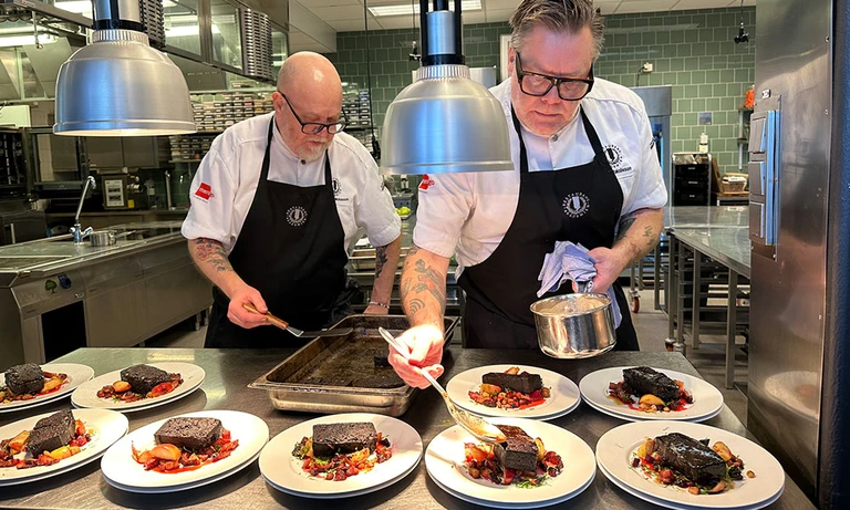 Två kockar lägger upp blodpudding