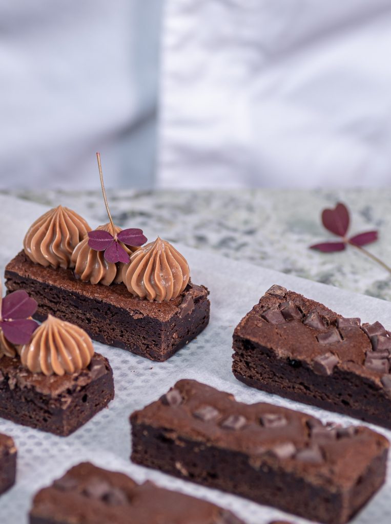Brownies skurna i avlånga bitar dekorerade med chokladkräm och oxyalis
